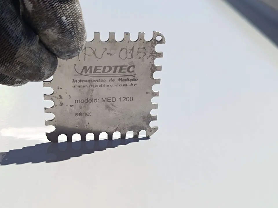 Pente medidor de película úmida sobre a tinta